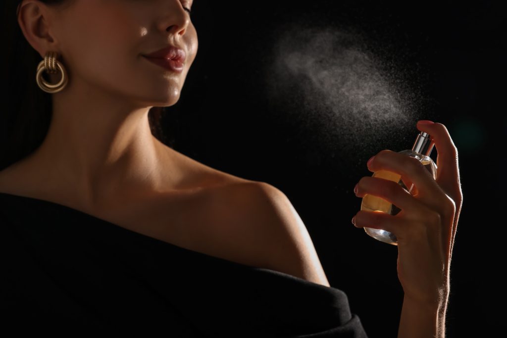 Buste de femme en train de se vaporiser un parfum de luxe