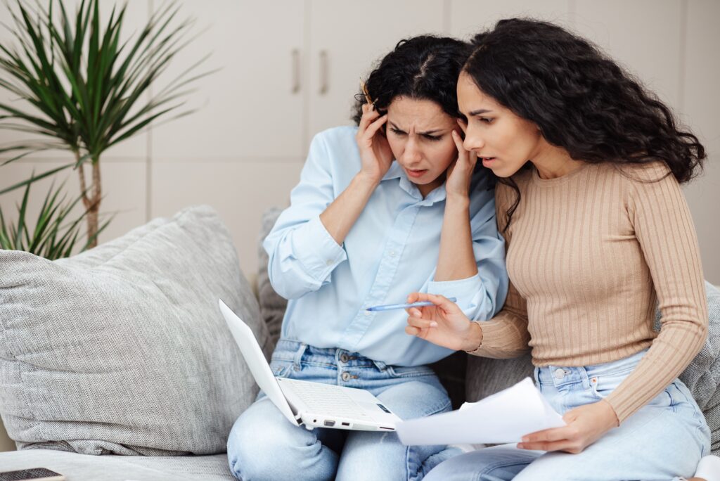 Deux femmes regardant un écran d'ordinateur avec perplexité car elles ne comprennent pas les erreurs de traduction