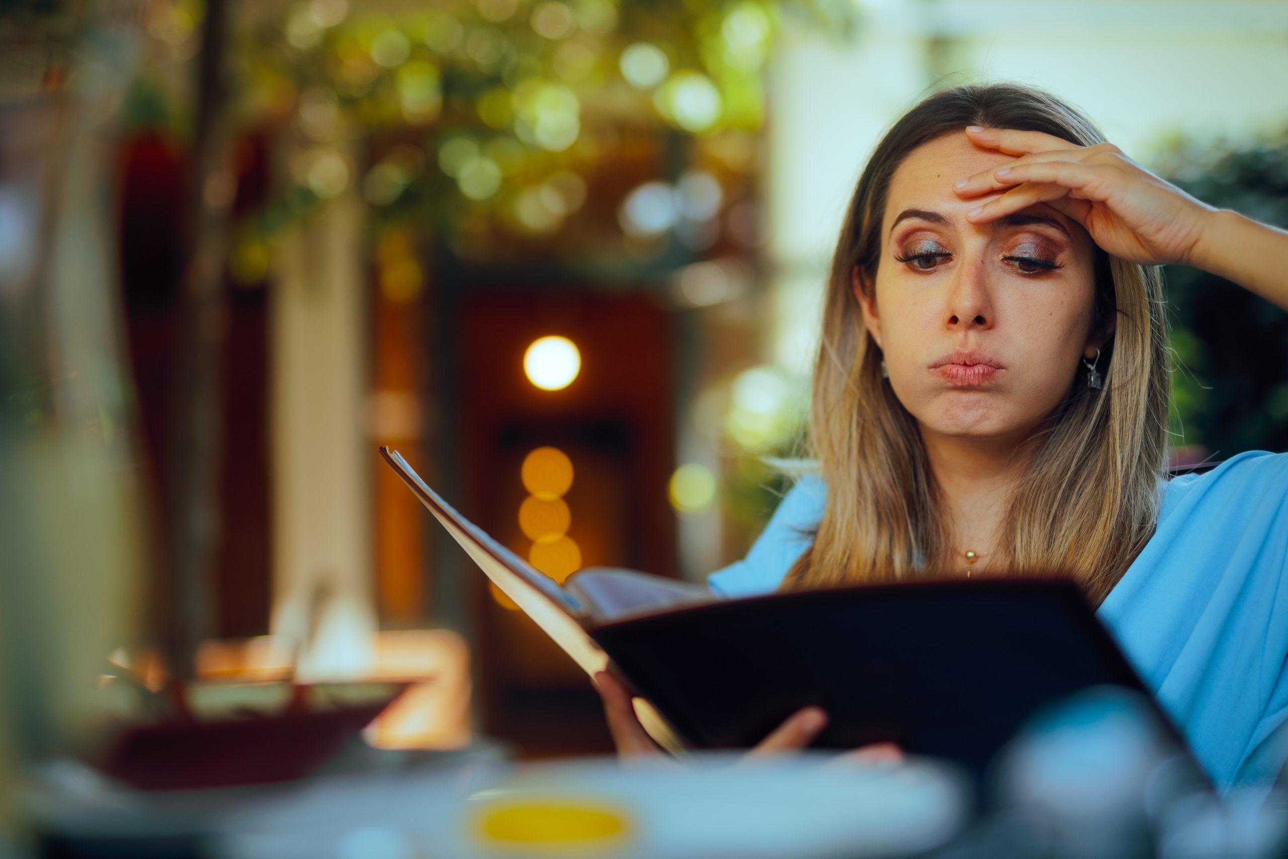 jeune femme ne comprenant pas la traduction de carte de restaurant