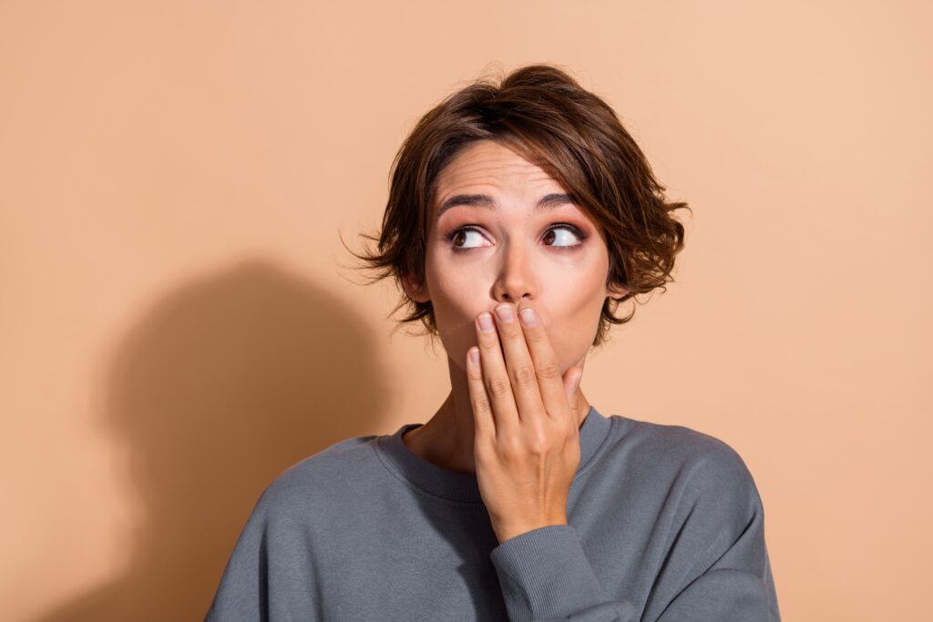 Jeune femme mettant sa main devant sa bouche suite à des erreurs de traduction