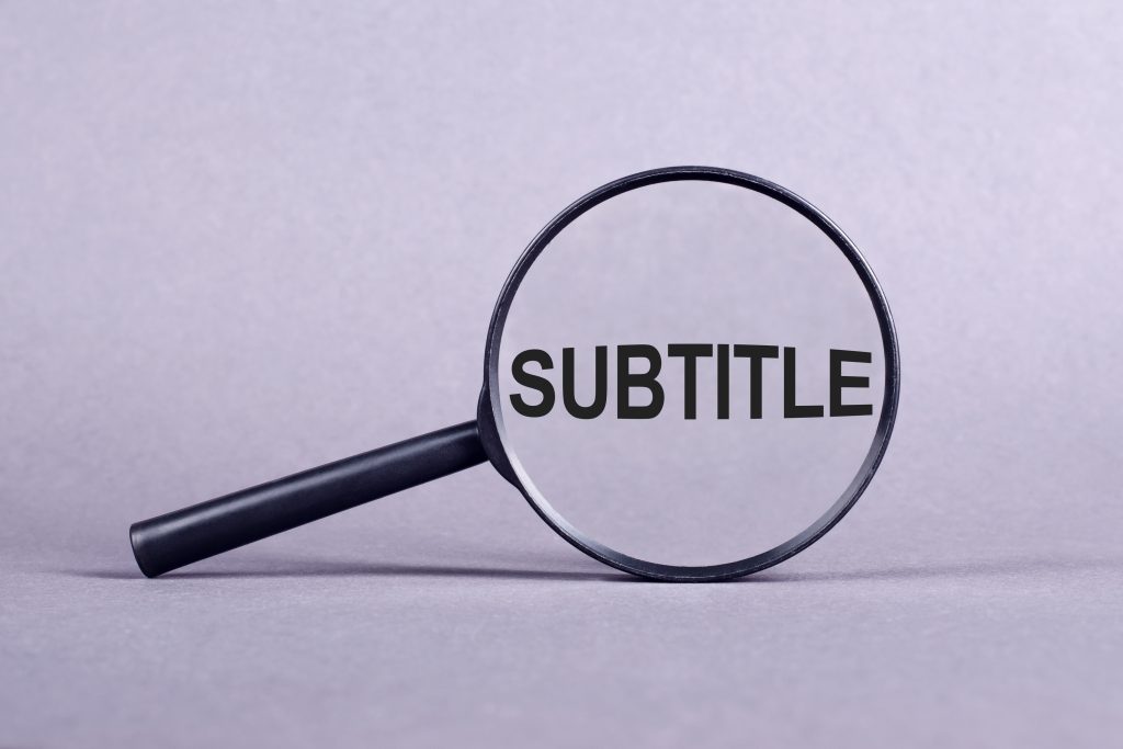 Vue en gros plan d'une loupe se concentrant sur le sous-titre du mot sur fond clair